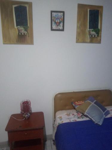 - une chambre avec un lit et deux photos sur le mur dans l'établissement Hotel Tanta Wasi-Panecillo, à Quito