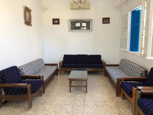 a waiting room with blue chairs and a table at Une maison djerbienne in Houmt Souk