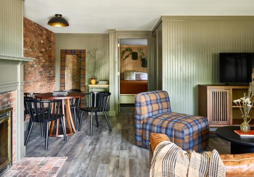 uma sala de estar com um sofá, uma mesa e cadeiras em Bluebird Cady Hill Lodge em Stowe