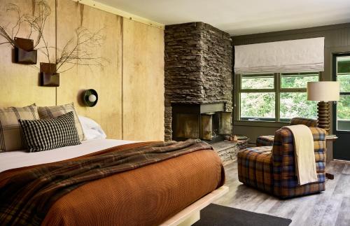 a bedroom with a large bed and a fireplace at Bluebird Cady Hill Lodge in Stowe