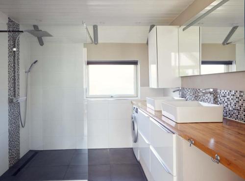 y baño con armarios blancos, lavabo y ducha. en Findus, en Brasilien
