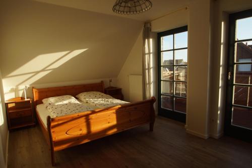 een slaapkamer met een houten bed en 2 ramen bij Linnea in Brasilien
