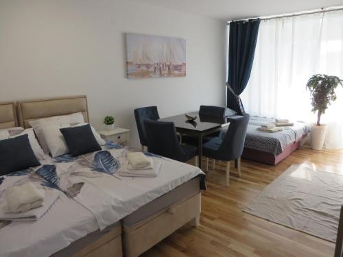 a bedroom with a bed and a table and chairs at Lux apartment 10 center, free parking in Niš