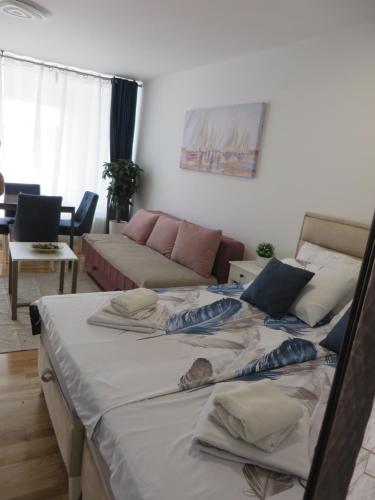two beds in a living room with a couch at Lux apartment 10 center, free parking in Niš