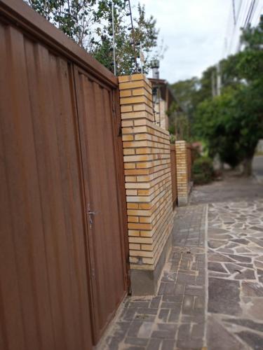 a wooden fence with a pile of logs next to it at Hospedaria das Azaleias in Novo Hamburgo