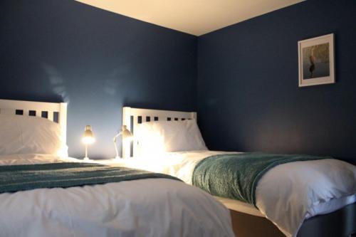 two beds in a bedroom with blue walls at The Tally Ho in Hungerford