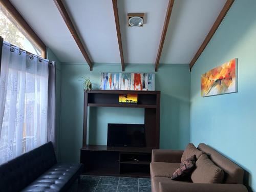sala de estar con sofá y TV en Alturas de Bocatoma, en Río Blanco