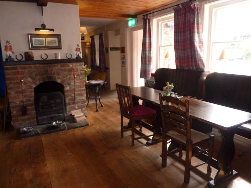a living room with a fireplace and a table and chairs at The Tally Ho in Hungerford