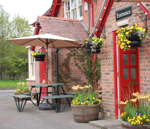 a picnic table and an umbrella in front of a building at The Tally Ho in Hungerford