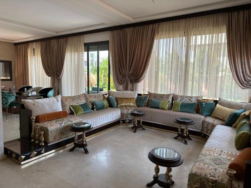 un soggiorno con divani, tavoli e finestre di Villa Novia a Marrakech
