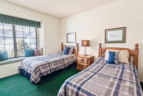 a bedroom with two beds and a window at 013 - Mountain Haven Condo in Big Bear Lake