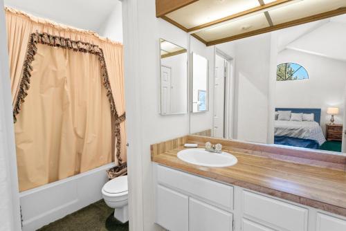 a bathroom with a sink and a toilet and a mirror at 013 - Mountain Haven Condo in Big Bear Lake