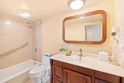 a bathroom with a sink and a toilet and a mirror at Diamond Head View Close to Waikiki Beach with Parking in Honolulu