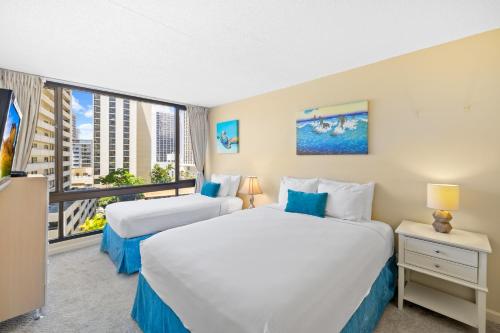two beds in a hotel room with a large window at Diamond Head View Close to Waikiki Beach with Parking in Honolulu