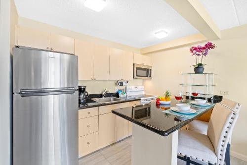 a kitchen with a stainless steel refrigerator and a table at Diamond Head View Close to Waikiki Beach with Parking in Honolulu