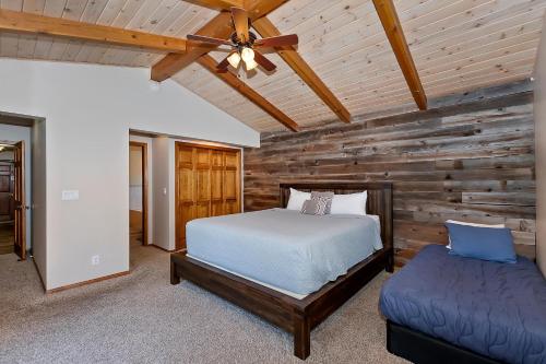 a bedroom with a bed and a wooden wall at 118 - Pinecrest Getaway in Big Bear Lake