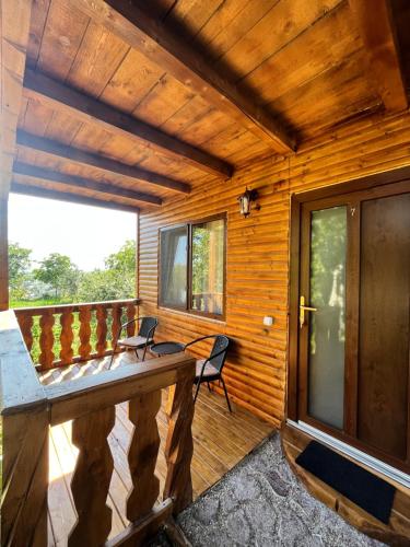 a wooden cabin with a table and chairs on a deck at Sunset Expanse in Turda