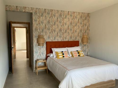 - une chambre avec un grand lit et un mur dans l'établissement Los Laureles, à Candeleda