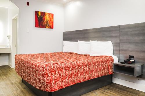 Habitación de hotel con cama con manta roja en Palace Inn 290 - Fairbanks, en Houston