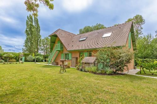 ein Haus mit einem grünen Dach und einem Hof in der Unterkunft L'Orée de Giverny in Limetz