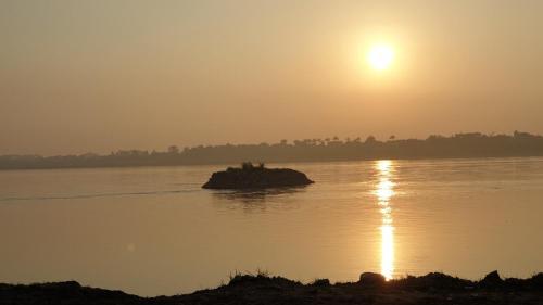 a sunset over a river with a small island in the water at Wyndham Thanh Thuy Hot Spring MyHome in Phú Thọ