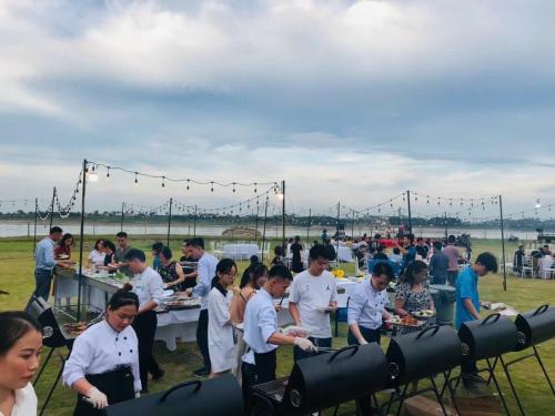 a group of people standing around a table with food at Wyndham Thanh Thuy Hot Spring MyHome in Phú Thọ