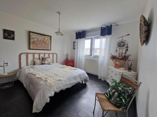 1 dormitorio con 1 cama, 1 silla y 1 ventana en Originally designed holiday home with garden in a central location, en Saint-Brieuc