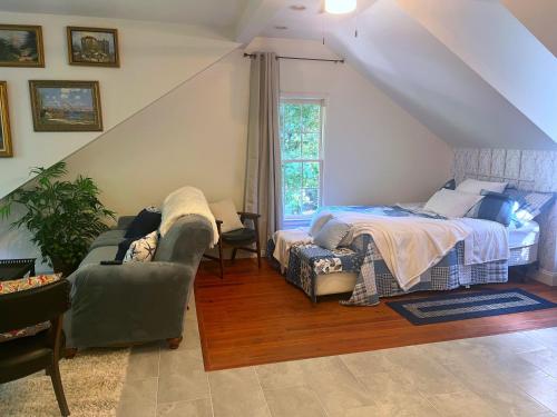 um quarto no sótão com uma cama e um sofá em Elegant Guest Studio in Upscale Community em Covington