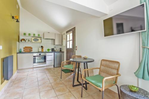 a kitchen with a table and chairs in a room at L'Orée de Giverny in Limetz