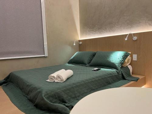 1 dormitorio con 1 cama verde y 2 toallas en Tiny Studio Nation Copacabana, en Río de Janeiro