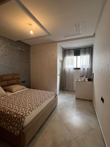 um quarto com uma cama grande e uma janela em Logement moderne et neuf entièrement équipé em Fez