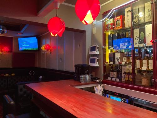 富岡市にあるお宿わいわいの赤い照明とバーカウンター付きのバー