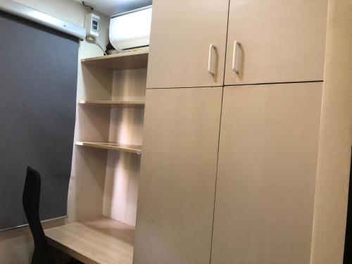 a closet with white cabinets in a room at Comfy Room With Single Sized Bed, Study Space, Closet, and WiFi in Manila