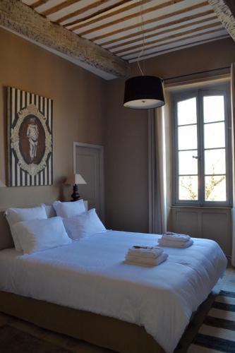 une chambre avec un grand lit blanc avec une fenêtre dans l'établissement Domaine de Ceyrac, à Conqueyrac