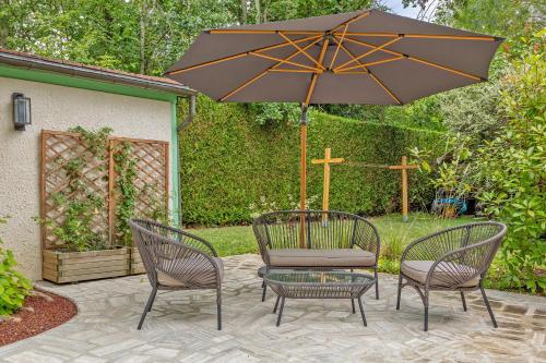 a patio with two chairs and a table with an umbrella at L'Orée de Giverny in Limetz