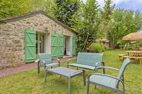 three chairs and a bench in front of a building at L'Orée de Giverny in Limetz