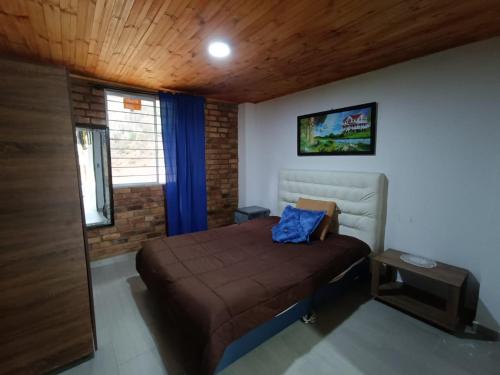 a bedroom with a bed and a television on the wall at El encanto in Paipa