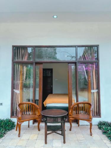 a room with a bed and two chairs and a table at De Summit Villa & View in Puncak