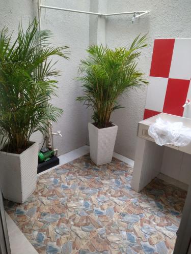 un bagno con 2 piante in vaso su un pavimento piastrellato di Casa Mompox a Mompós