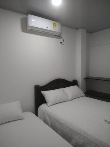 1 dormitorio con 2 camas y TV en la pared en Casa Mompox, en Mompox