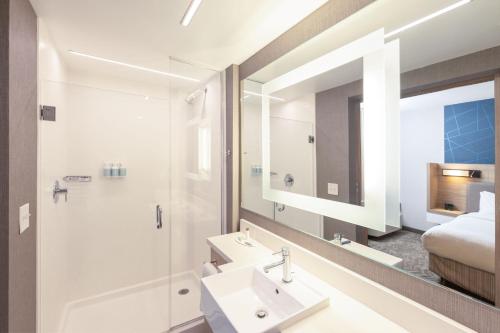 a bathroom with a sink and a shower and a bed at SpringHill Suites by Marriott Austin Cedar Park in Cedar Park