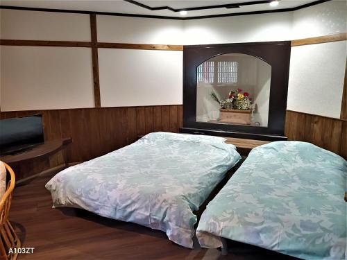 a bedroom with two beds and a mirror at ホテル亀岡 in Minamijō