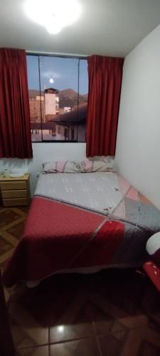 um quarto com uma cama com um cão deitado sobre ela em Hotel Águila Real em Huancayo