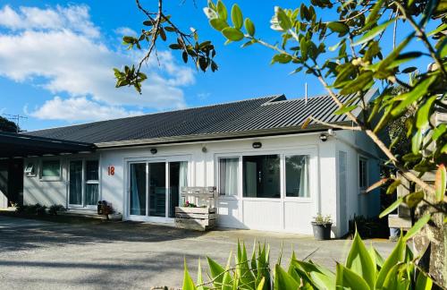 a white house with a garage at Tutukaka Sunrise in Tutukaka