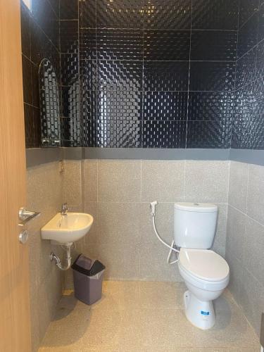 a bathroom with a toilet and a sink at Wisma Lotus 2 Syariah in Banyumas