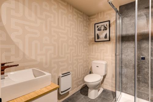 a bathroom with a toilet and a sink and a shower at North House - Quebec City 2 Bedroom Treasure in Quebec City