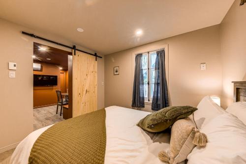 魁北克市的住宿－Quebec City 2 Bedroom Treasure，一间卧室配有一张带白色床单的床和一扇窗户。