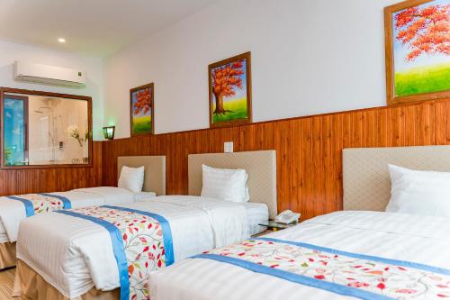 Cette chambre d'hôtel comprend 3 lits avec des draps blancs. dans l'établissement Bình An Nhiên hotel, à Ninh Binh