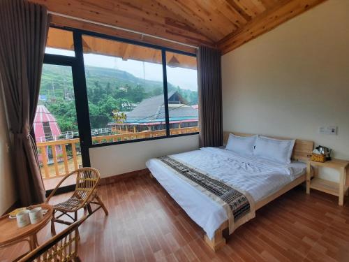 ein Schlafzimmer mit einem Bett und einem großen Fenster in der Unterkunft Chapa Stream House in Sa Pa