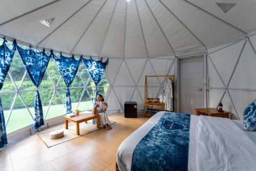 eine Frau sitzt in einem Zelt in der Unterkunft Ikigawa Home in Ban Pha Khap